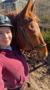 Jessica McDonald smiling and taking a selfie with her horse.