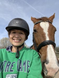 Marisa Fernandez smiling and posing while taking a selfie with her horse.