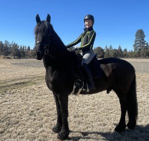 Rebekah Warbington smiling and posing on her horse.