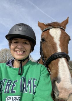 Marisa Fernandez smiling and posing while taking a selfie with her horse.